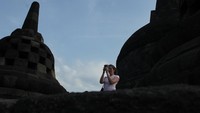 Foto: Seorang wisatawan tengah asyik mengabadikan pemandangan sekitar dengan kameranya (Randy/detikTravel)