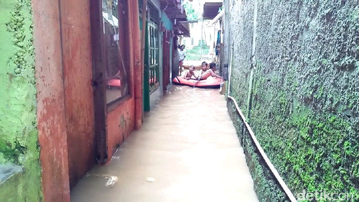 Anak-anak Asyik Bermain Perahu di Tengah Banjir Tebet
