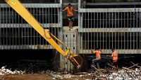 Petugas sibuk membersihkan sampah rumah tangga hingga batang bambu yang menyangkut di pintu air.
