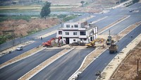 Mengutip dari VOA, rumah paku tiga tingkat, bangunan terakhir di wilayah itu, dengan bendera nasional China di atapnya tampak di tengah jalan yang baru dibangun di Luoyang, provinsi Henan, China. Menurut media setempat, pemilik rumah tersebut tidak setuju dengan biaya kompensasi untuk relokasi dan menolak pindah. (Reuters)