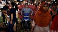 Seorang pedagang membawa bawang mereka yang akan dijual.