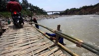 Warga terlihat tengah mengerjakan pembangunan jembatan bambu.