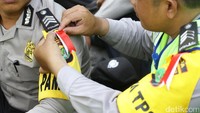 Selain pin Aman, Ada Kami, pasukan gabungan TNI-Pori juga memakai pita merah putih.