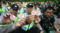 Personel gabungan TNI-Polri menunjukkan pin Aman, Ada Kami.