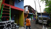 Seorang warga melintas di kampung yang telah dicat warna-warni.