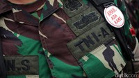 Pasukan pengamanan yang berjaga diberikan pin bertuliskan Aman, Ada Kami.