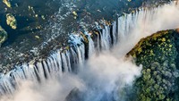 Air Terjun Niagara di perbatasan Kanada-AS memang terlihat lebar dan begitu indah, tapi ternyata ada yang lebih lebar lagi. Itulah Victoria Falls atau Air Terjun Victoria (Thinkstock)