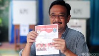 Djarot mengenakan kemeja abu-abu sedangkan istrinya mengenakan kemeja khas kotak-kotak. Keduanya terus melempar senyum selama berada di TPS.