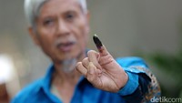 Seorang warga menunjukan jarinya usai mencoblos.