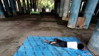 Seorang warga tertidur di dekat TPS.