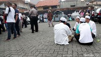Sejumlah warga menunggu hasil penghitungan suara dengan duduk-duduk di luar pembatas TPS.