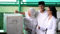Sandiaga dan keluarga dengan ceria memasukan kertas suara ke kotak suara.