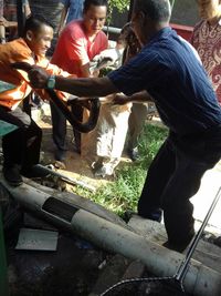 Empat karyawan RS berusaha menangkap ular sanca