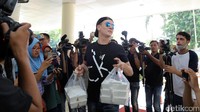 Ia tampak membawakan beberapa bungkus makanan.