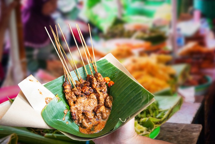 Indonesian chicken satay served in leaf on the food market