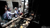 Sejumlah siswa SD tengah berjalan diantara puing-puing rumah yang terbakar.