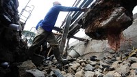 Para pekerja tengah memperbaiki turap yang longsor.