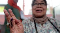 Seorang warga menunjukkan jari kelingking yang telah dicelupkan ke tinta.