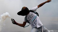 Seorang demonstran melempari polisi dengan gas air mata. Carlos Garcia Rawlins/Reuters.