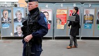 (Seorang polisi berjaga di sebuah TPS di Henin-Beaumont, Prancis. (REUTERS/Pascal Rossignol)