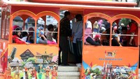 Warga berkeliling Taman Mini Indonesia Indah (TMII) menggunakan kereta.