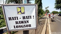 Papan pengumuman rawan longsor terpampang di sekitar sungai.