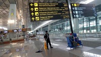 Seorang pekerja membersihkan lantai Terminal 3.