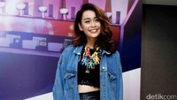 Conchita Caroline tampil dengan jaket denim, crop top dan rok hitam serta heels pink. Pool/Noel/detikFoto.