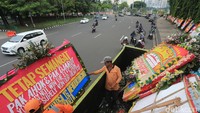 Karangan bunga itu diletakkan di luar pagar yang menghadap ke jalan bukan di dalam area Monas.