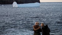 Momen tersebut langsung diabadikan oleh sejumlah turis yang sengaja datang untuk melihat gunung es tersebut. Drew Angerer/Getty Images.