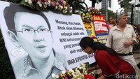 Seorang turis melihat karangan bunga yang dikirimkan untuk Ahok.