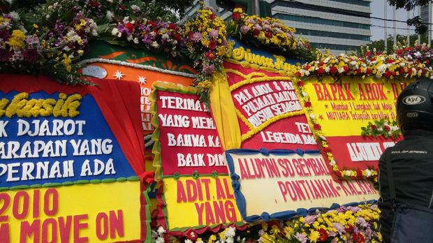 Saking membeludak, karangan bunga itu dipasang bertumpuk-tumpuk.