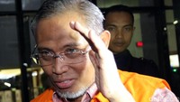 Sambil menutupi wajahnya Firmansyah Arifin terus berjalan menuju mobil tahanan KPK.