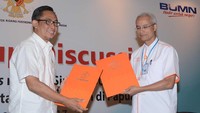 Direktur Pemasaran dan Supply Chain PT Semen Indonesia Tbk Ahyanizzaman (kiri) dan Dirut PT Pos Indonesia Gilarsi Wahyu Setiono, bertukar naskah kerja sama yang telah ditandatangani. Dok, Semen Indonesia.