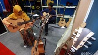 Pengunjung menjajal gitar yang dipamerkan.