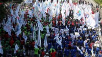 Mereka long march sambil mengibarkan bendera organisasi buruh.