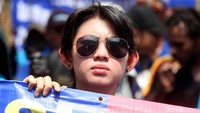 Dengan memakai kacamata hitam, buruh ini ikut membentangkan spanduk tuntutan.