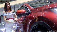 SPG berpose dengan mobil yang dipamerkan.