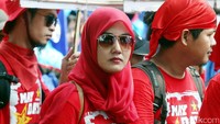 Selain mengenakan pakaian serba merah, seorang peserta aksi May Day ini juga memakai kacamata.