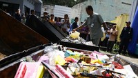 Petugas menuangkan besin ke barang yang akan dibakar.