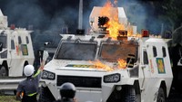 Demonstran membakar mobil polisi. REUTERS/Carlos Garcia Rawlins.