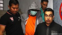 Pria 47 tahun ini keluar dengan pengamanan ketat dari beberapa pihak dengan memakai jaket abu-abu, ditutupi dengan topi jaket yang dikenakannya, serta masker hijau yang menutupi sebagian wajahnya.