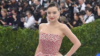 Miranda Kerr mengenakan gaun silver dengan motif bunga-bunga berwarna merah. Foto: Theo Wargo/Getty Images