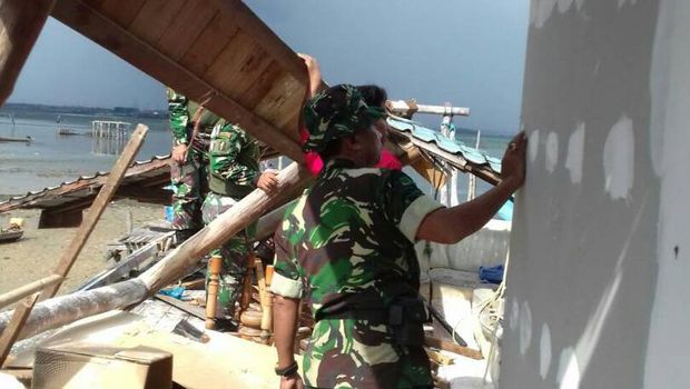 Personel TNI AD ini sigap menyingsingkan lengan membantu warga.
