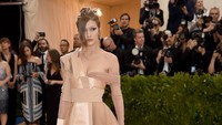 Gigi Hadid tampak seksi dan menawan dengan gaun rancangan Tommy Hilfiger yang dipadukan dengan stoking jaring dan heels hitam. Neilson Barnard/Getty Images/detikFoto.