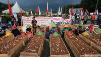 Ini penampakan sejumlah petani Telukjambe, Kabupaten Karawang menggelar aksi kubur diri di seberang Patung Kuda, tepatnya di pintu barat Monumen Nasional.