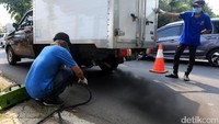 Setiap kendaraan yang melintas diuji emisinya oleh petugas BPLHD DKI Jakarta.