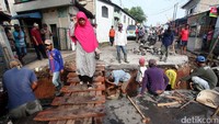 Untuk sementara, petugas membuat titian dari kayu untuk pejalan kali melintas.