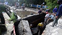 Sejumlah pekerja memperbaiki jembatan Kali Krukut di Jalan Pitara, Depok yang amblas, Rabu (3/5).