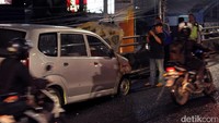 Pengndara melintas di samping mobil yang terbakar. Pool/Rio Soebekti.